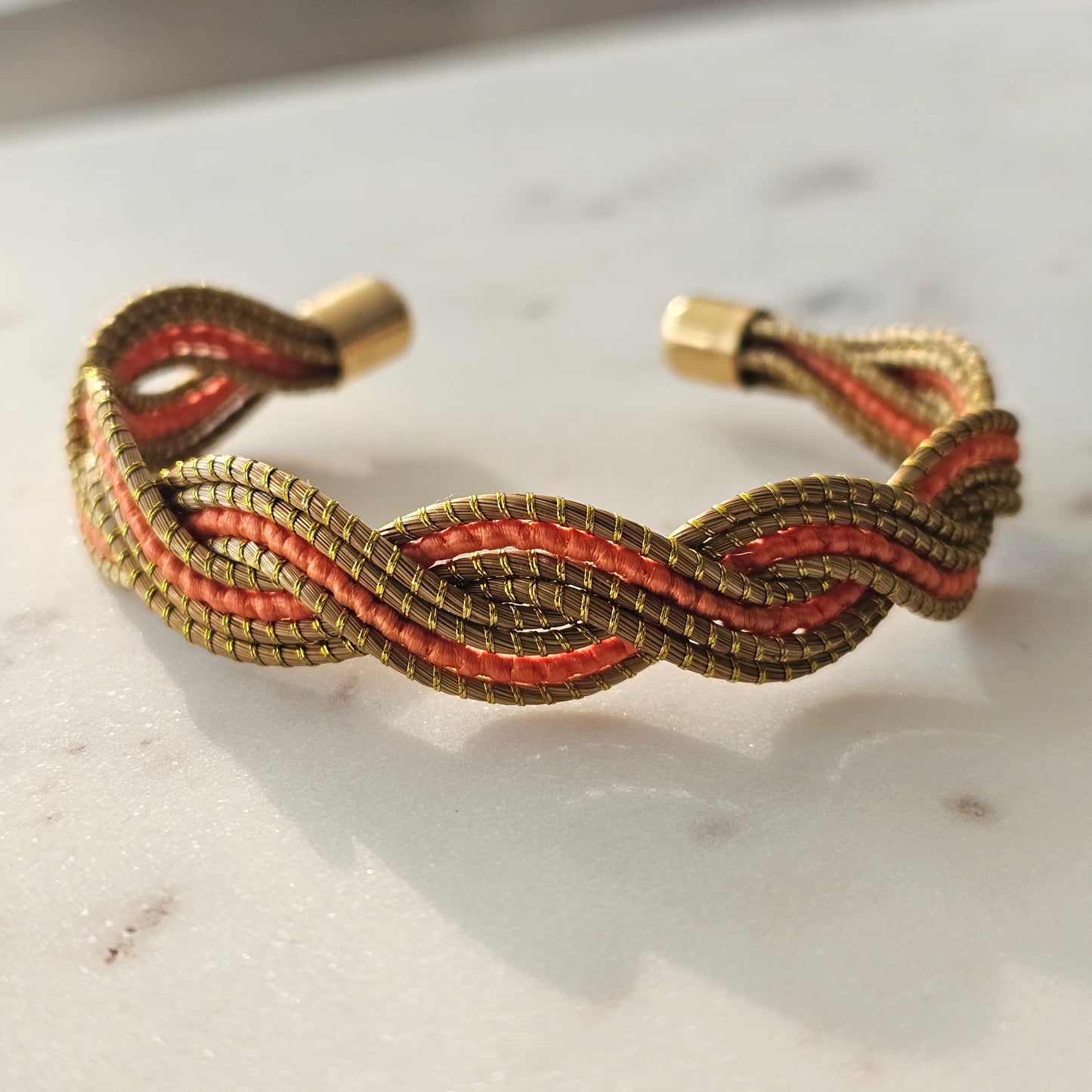 Thick Golden Grass Bracelet with vibrant orange accents.