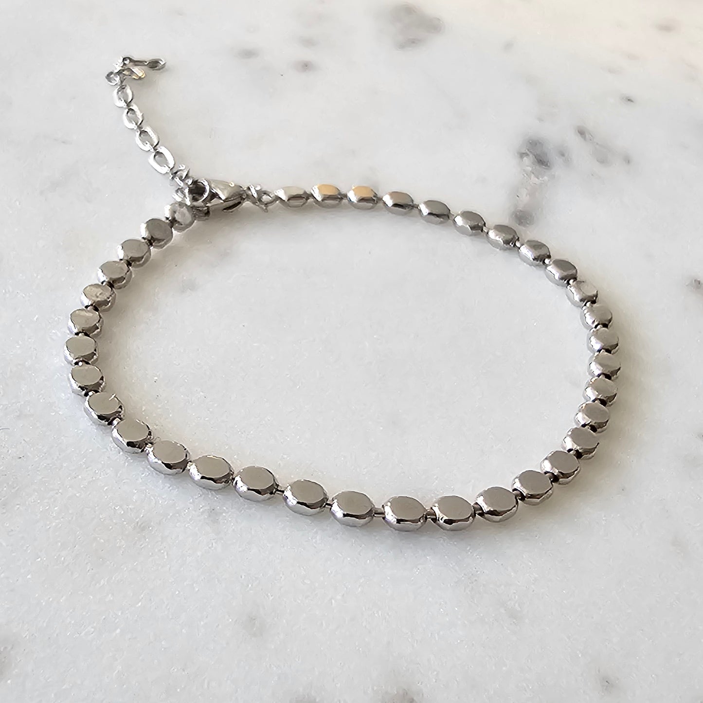 White Rhodium Plated Bracelet with minimalist dot accents.
