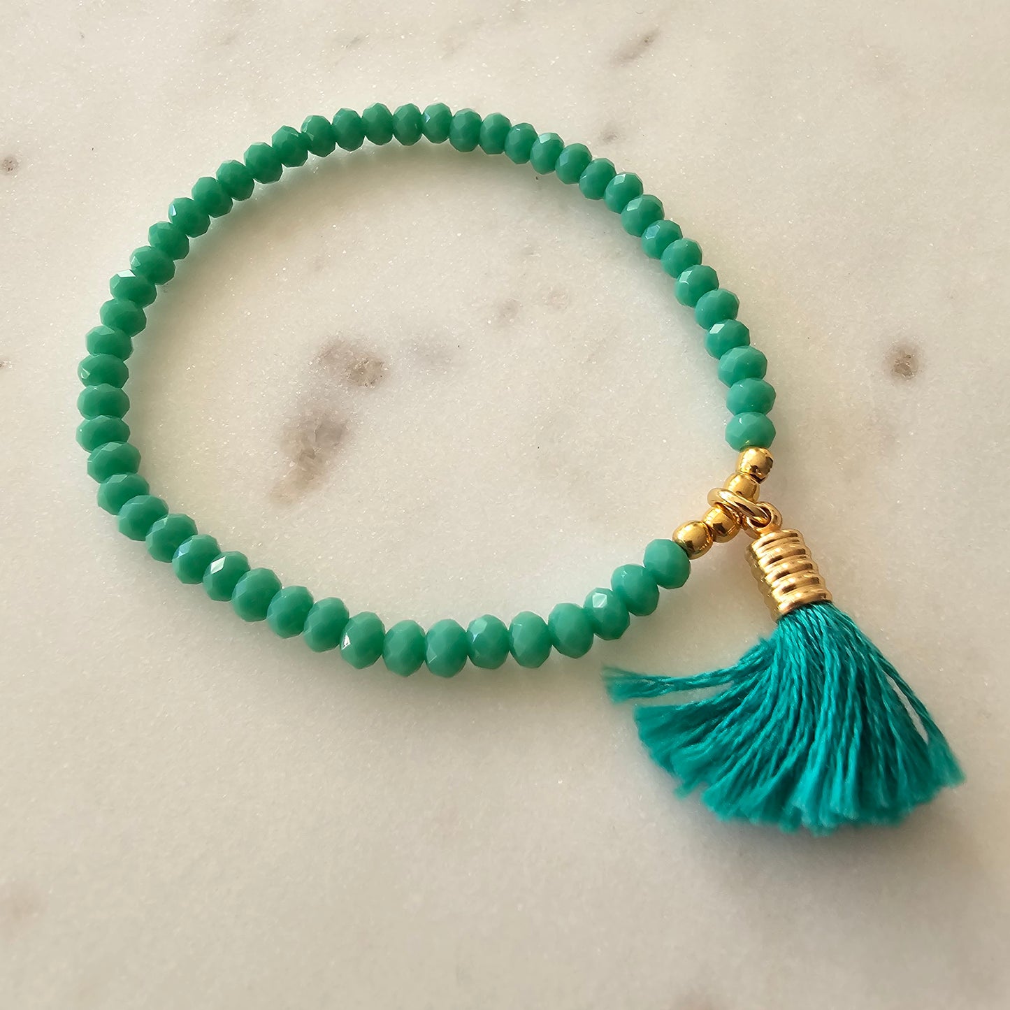 18K Gold Plated Bracelet with light green crystals and pompom accents.