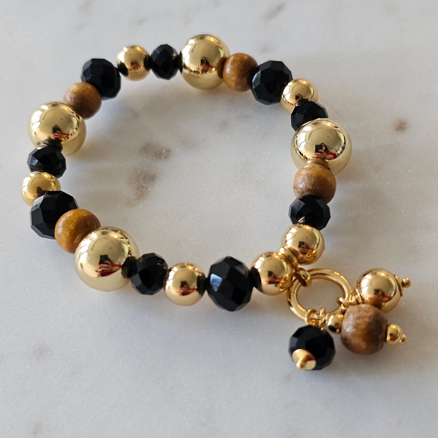 18K Gold Plated Bracelet with wood balls and black crystals.